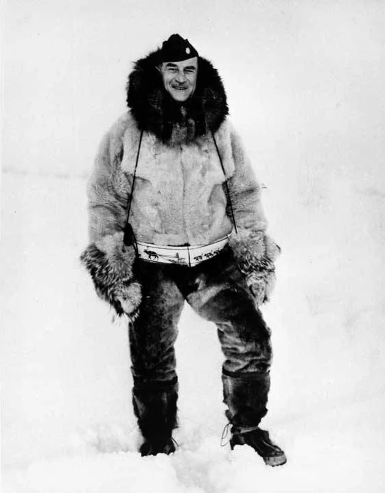 Muktuk Marston in military cap and fur parka, pants, and mukluks